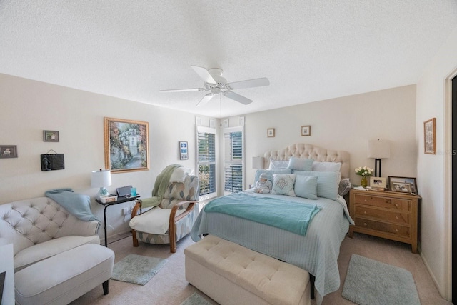 bedroom with ceiling fan, a textured ceiling, and light colored carpet