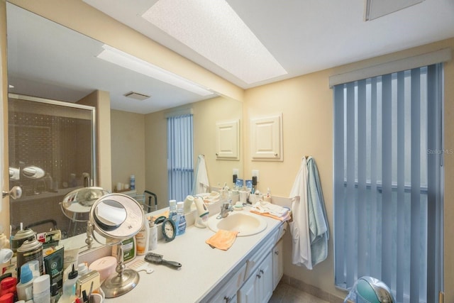 bathroom featuring vanity, tile patterned flooring, and a shower with door