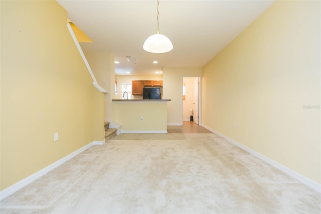 unfurnished living room with light carpet and sink