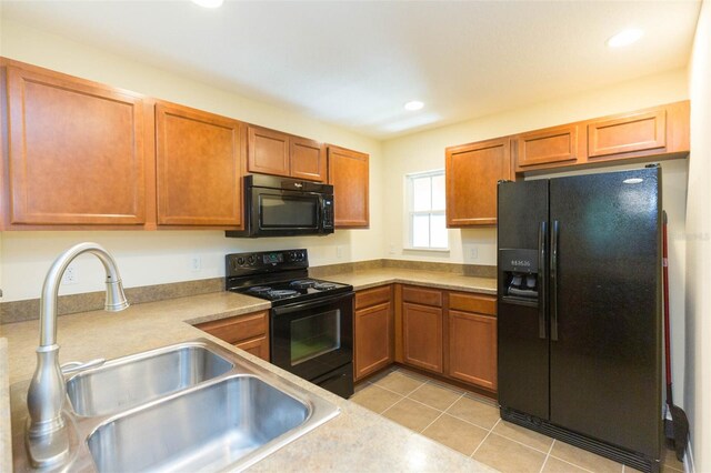 kitchen featuring light tile patterned floors, sink, and black appliances