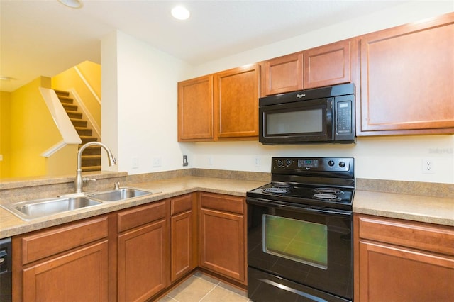 kitchen featuring black appliances, sink, and light tile patterned floors