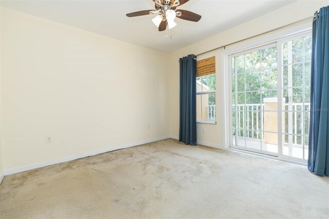 spare room with ceiling fan and light colored carpet