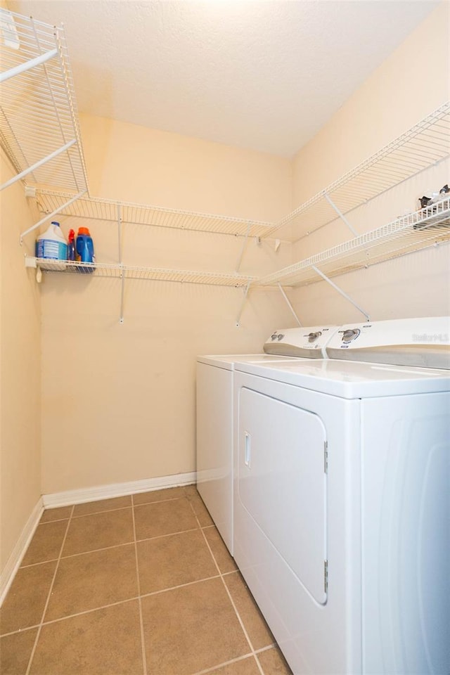 washroom featuring washing machine and dryer and tile patterned floors