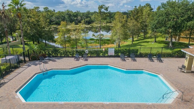 view of pool featuring a patio and a water view