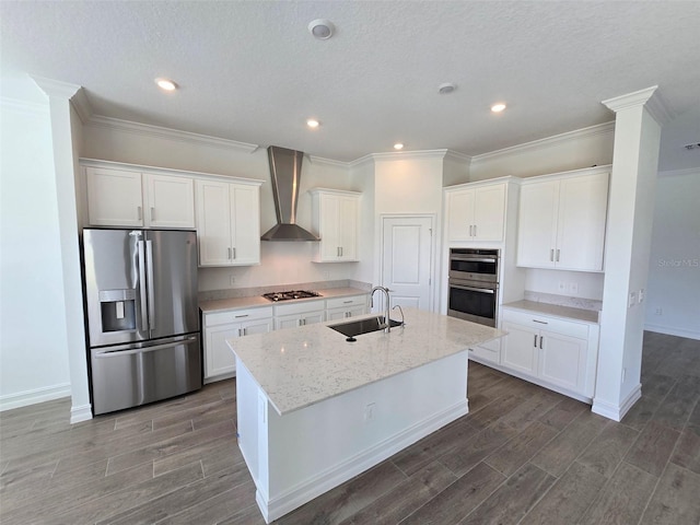 kitchen featuring a center island with sink, light stone countertops, sink, wall chimney exhaust hood, and stainless steel appliances