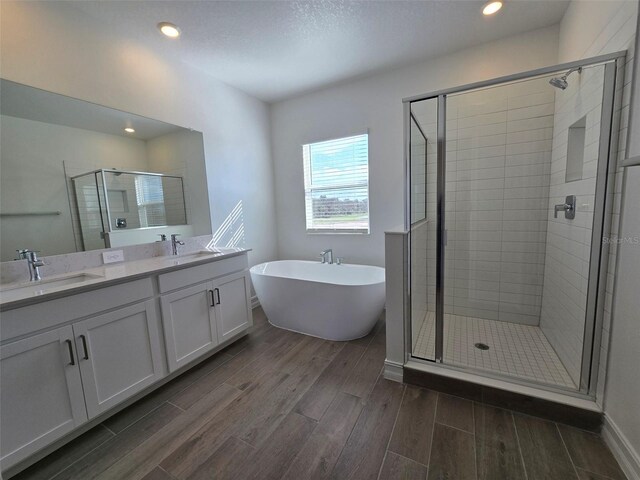 bathroom with vanity, shower with separate bathtub, and hardwood / wood-style floors