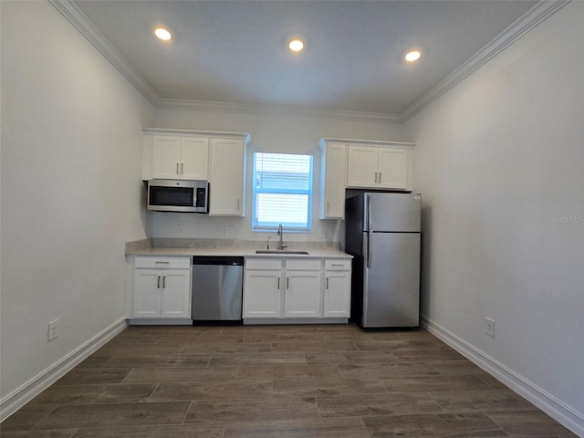 kitchen featuring ornamental molding, appliances with stainless steel finishes, sink, and white cabinets