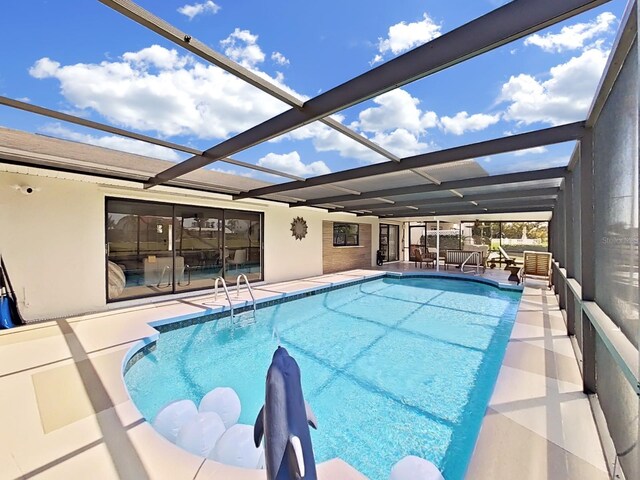 view of swimming pool featuring a patio area and glass enclosure