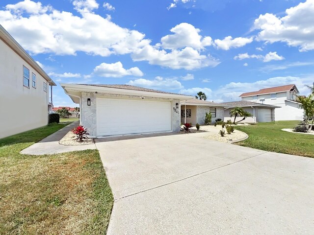 ranch-style home with a garage and a front lawn