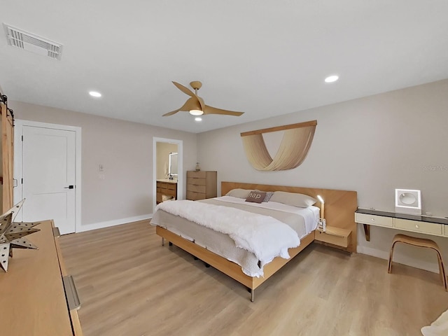 bedroom with ceiling fan, ensuite bathroom, and light hardwood / wood-style floors