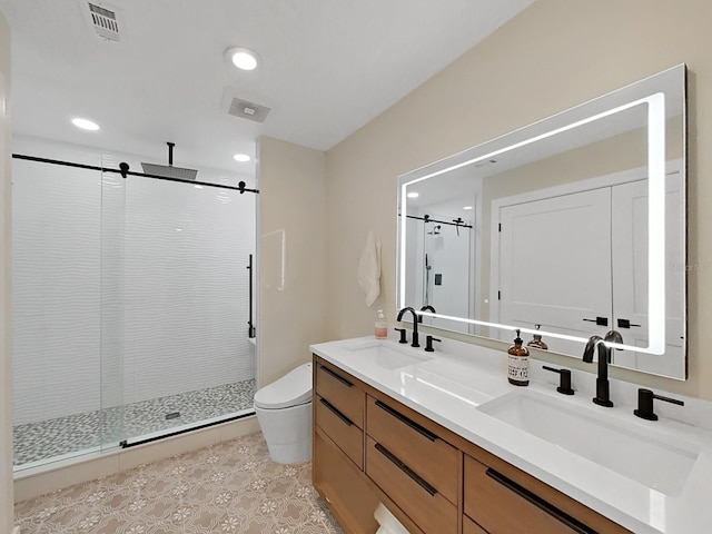 bathroom with tile patterned floors, vanity, toilet, and a shower with door