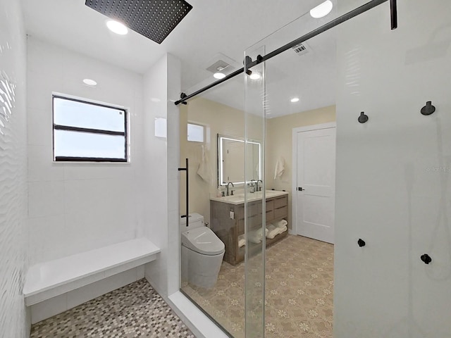 bathroom with vanity, a shower with shower door, and toilet