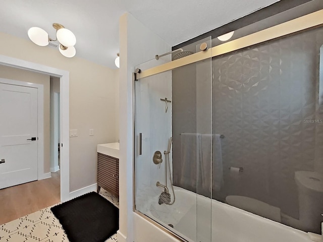 bathroom with hardwood / wood-style flooring and enclosed tub / shower combo