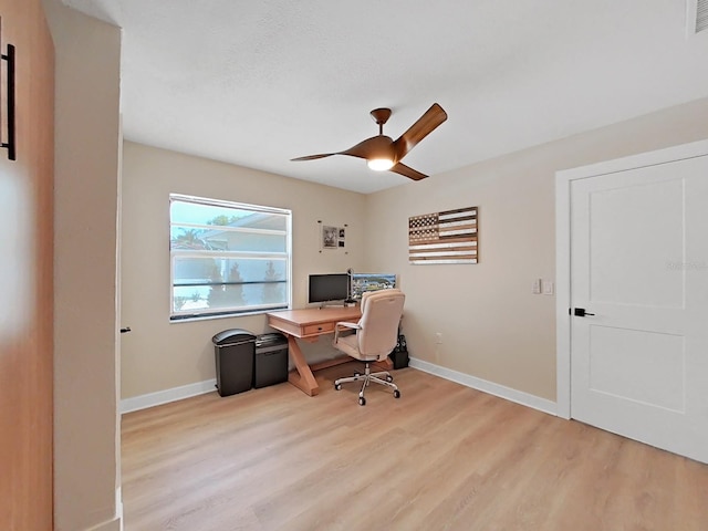 home office with light hardwood / wood-style flooring and ceiling fan