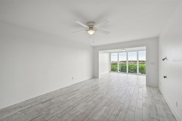 empty room with ceiling fan and light hardwood / wood-style flooring