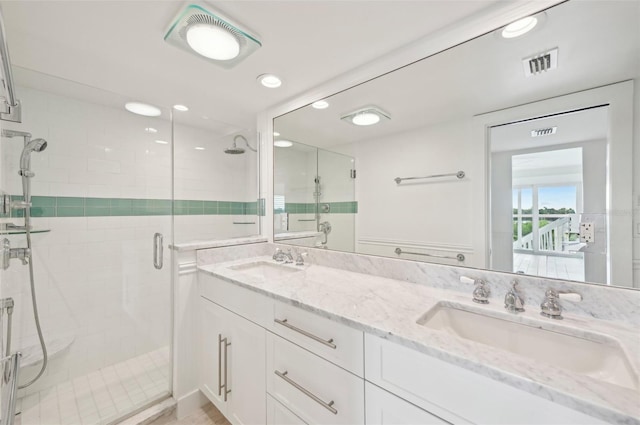 bathroom with vanity and a shower with shower door