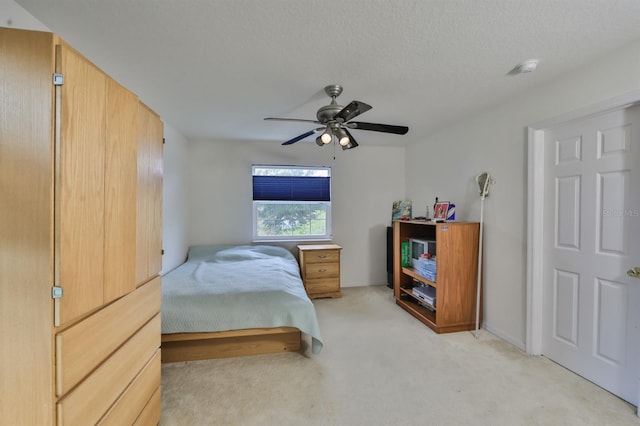 bedroom with ceiling fan, a textured ceiling, and light colored carpet