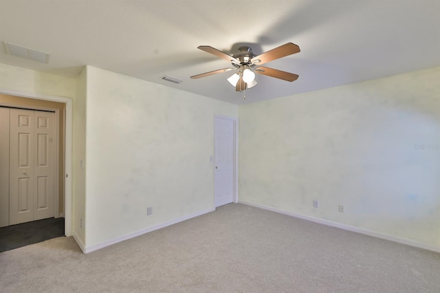 carpeted spare room featuring ceiling fan