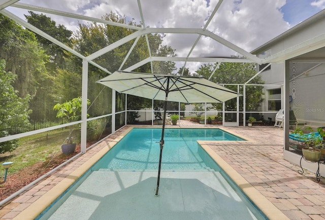 view of swimming pool with a patio area and a lanai