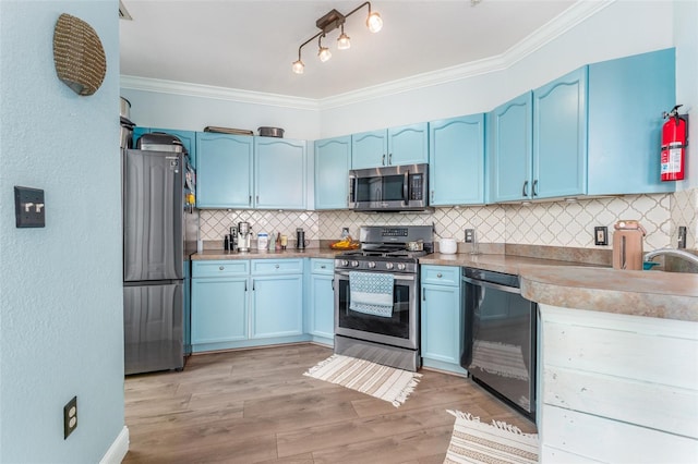 kitchen featuring light hardwood / wood-style floors, backsplash, appliances with stainless steel finishes, ornamental molding, and blue cabinets