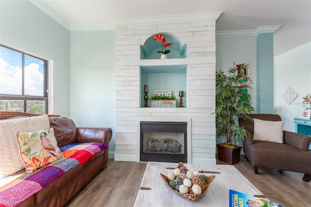 living room with a fireplace, crown molding, and light hardwood / wood-style floors