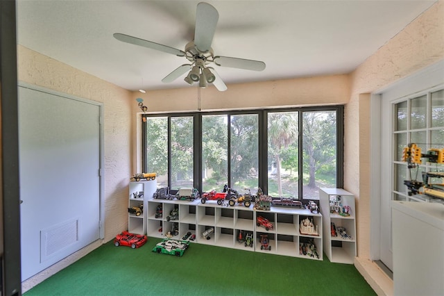 rec room with ceiling fan and carpet floors