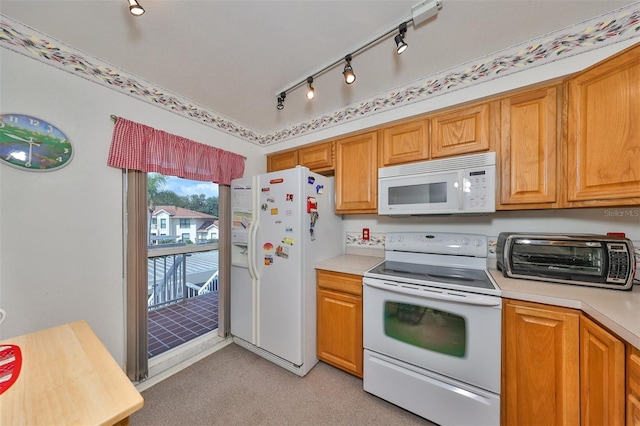 kitchen featuring white appliances, light colored carpet, and rail lighting