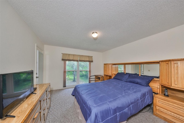 bedroom featuring light carpet and a textured ceiling