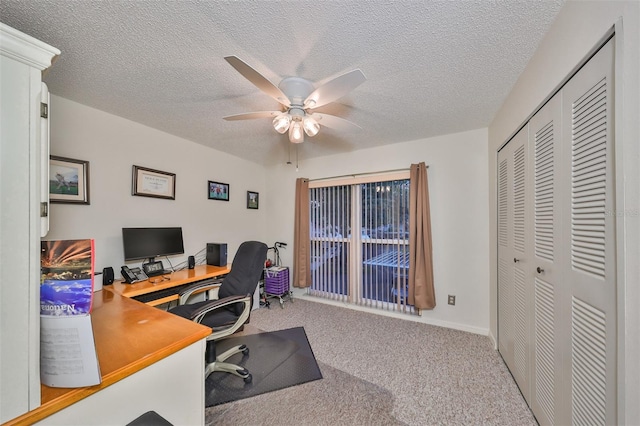 carpeted office space featuring ceiling fan and a textured ceiling