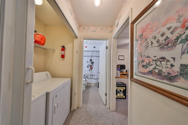 washroom with a textured ceiling, light colored carpet, and separate washer and dryer