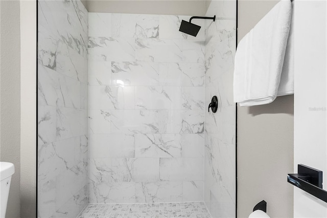 bathroom featuring a tile shower and toilet