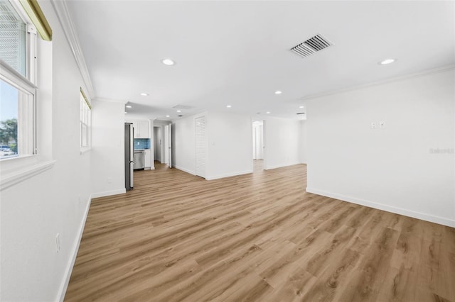 unfurnished living room with light hardwood / wood-style floors and crown molding