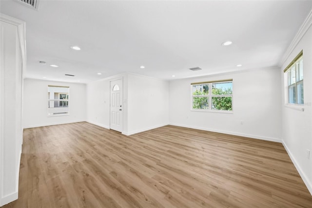 spare room with ornamental molding and light hardwood / wood-style flooring