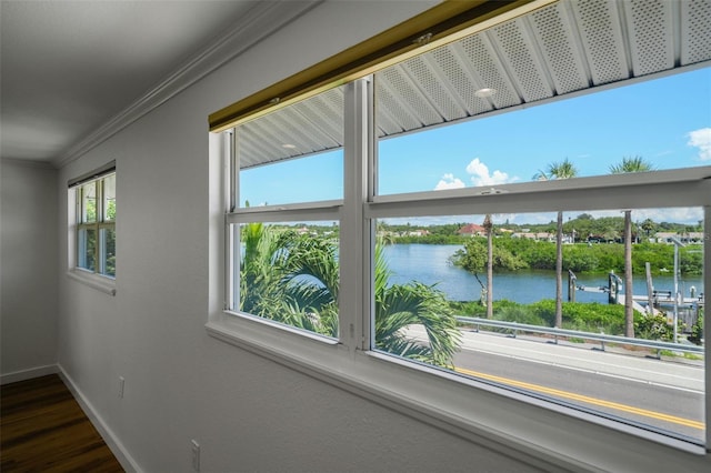 interior space featuring a water view, hardwood / wood-style flooring, and ornamental molding