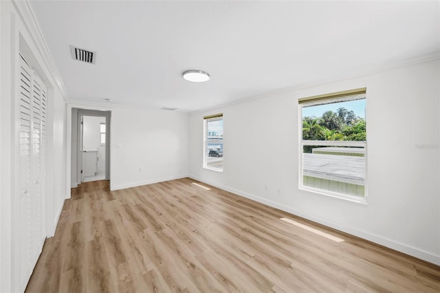 spare room with light hardwood / wood-style floors and ornamental molding