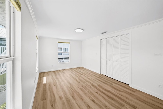 unfurnished bedroom featuring ornamental molding, a closet, and light hardwood / wood-style floors