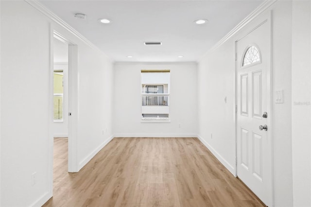 foyer with light hardwood / wood-style floors, plenty of natural light, and ornamental molding