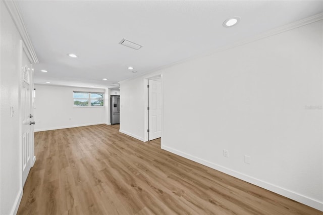 empty room featuring ornamental molding and light wood-type flooring