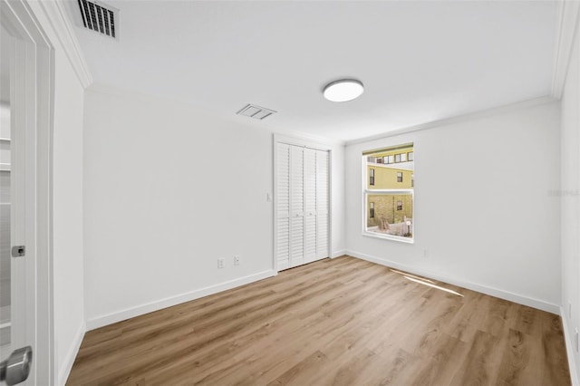 empty room featuring hardwood / wood-style flooring and ornamental molding