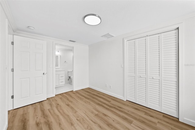 unfurnished bedroom featuring connected bathroom, light hardwood / wood-style floors, and crown molding