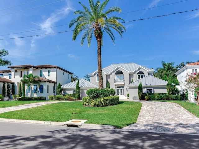 view of front of house with a balcony and a front lawn