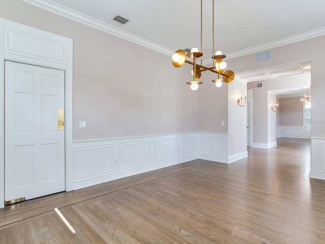 2509 N Dundee St, Tampa, FL 33629 - unfurnished dining area featuring a chandelier, ornamental molding, wood finished floors, a decorative wall, and wainscoting