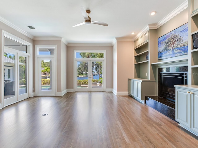 unfurnished living room featuring light hardwood / wood-style flooring, ornamental molding, french doors, and ceiling fan