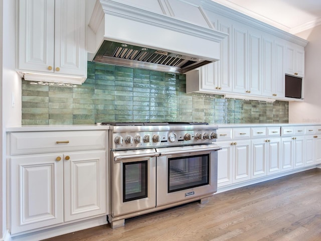 kitchen with range with two ovens, backsplash, light hardwood / wood-style flooring, and premium range hood