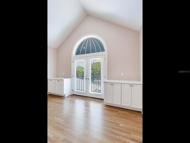 interior space with light hardwood / wood-style flooring, french doors, and lofted ceiling