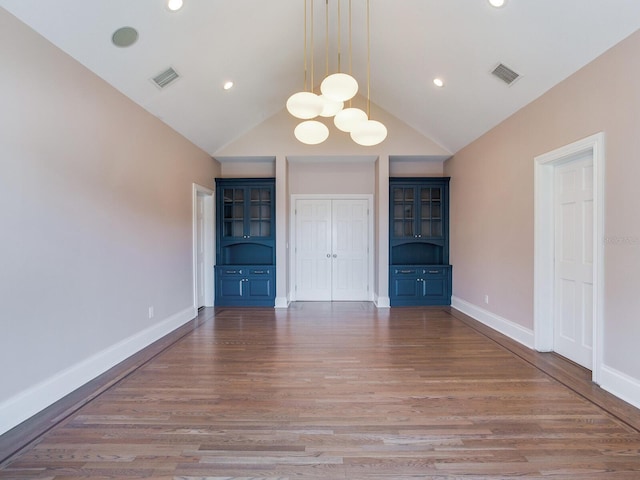 unfurnished bedroom with an inviting chandelier, high vaulted ceiling, and light wood-type flooring