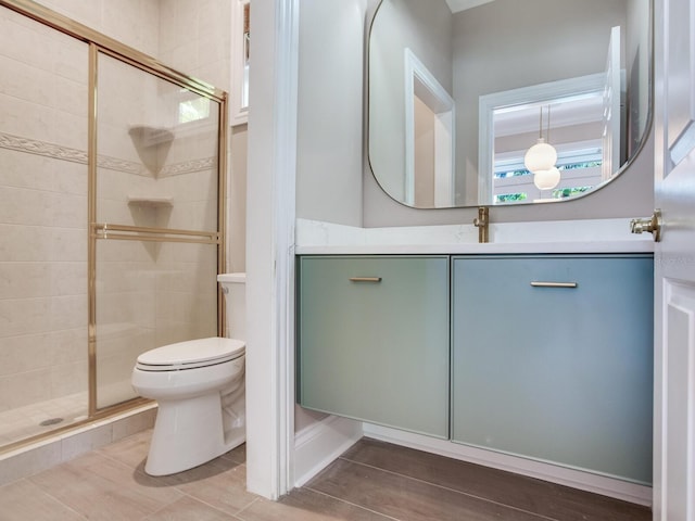 bathroom with vanity, toilet, hardwood / wood-style flooring, and an enclosed shower