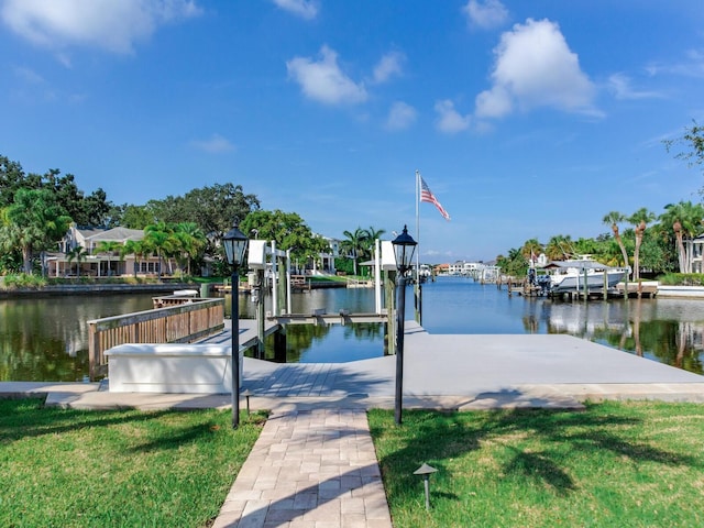 view of dock featuring a water view and a yard