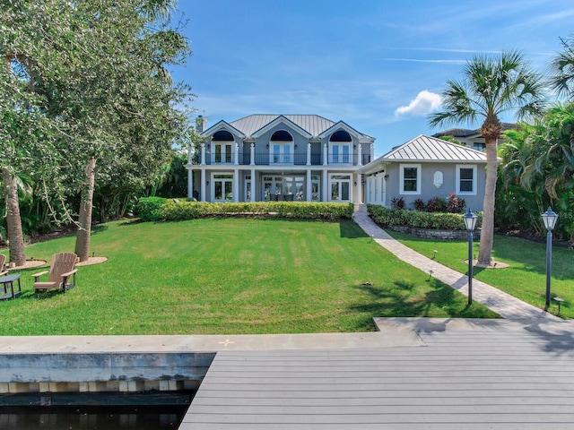 view of front of property featuring a front yard and a balcony