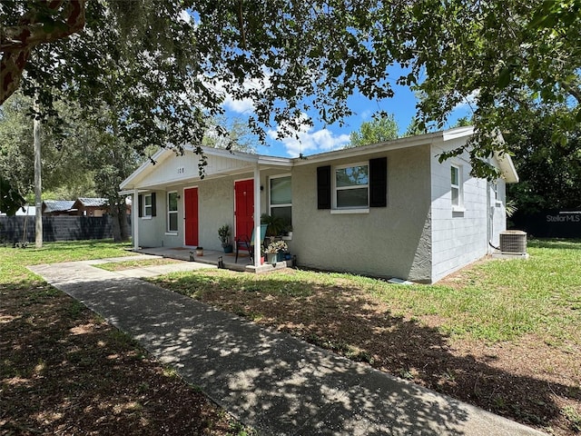 ranch-style home featuring central AC unit and a front yard